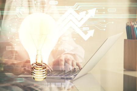 Double exposure of woman hands typing on computer and light bulb drawing. Idea concept.の写真素材