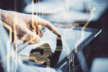 Double exposure of man's hands holding and using a digital device and tech theme hologram drawing....