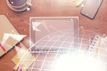 Double exposure of map hologram drawing over desktop. Top view. International connection concept.の写真素材
