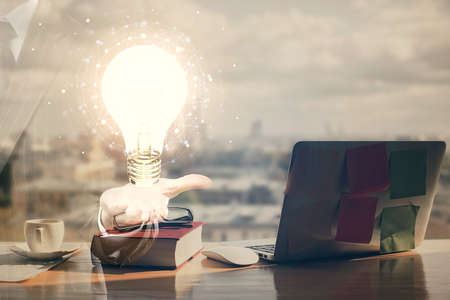 Double exposure of bulb drawing and desk with open notebook background. Concept of idea