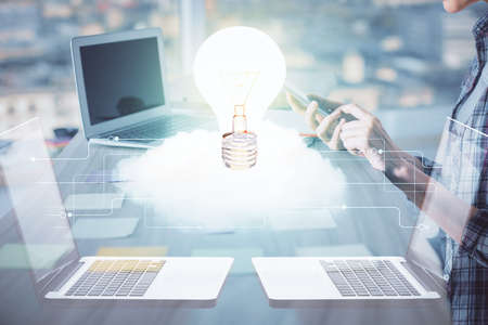 Double exposure of woman hands typing on computer and light bulb drawing. Idea concept.
