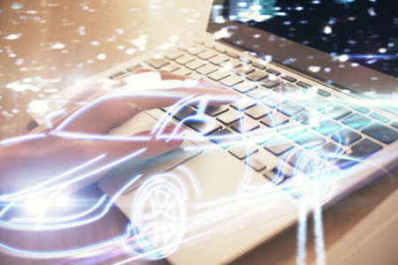 Double exposure of woman hands typing on computer and automobile theme drawing. High Tech concept.
