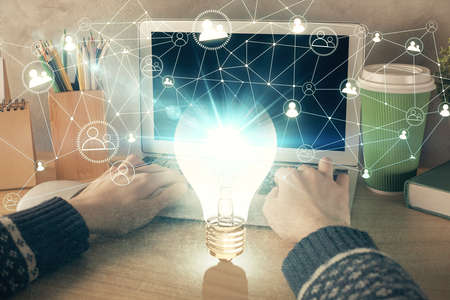 Double exposure of woman hands typing on computer and light bulb drawing. Idea concept.の写真素材