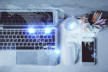 Social network hologram drawings over computer on the desktop background. Top view. Multi exposure....