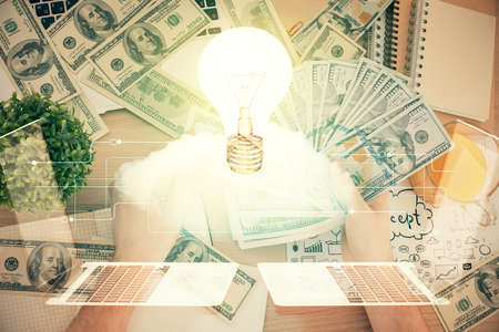 Multi exposure of bulb drawing hologram and USA dollars bills and man hands. Business Idea concept.