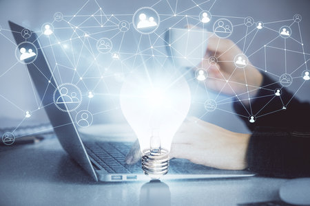 Double exposure of woman hands typing on computer and light bulb drawing. Idea concept.の写真素材