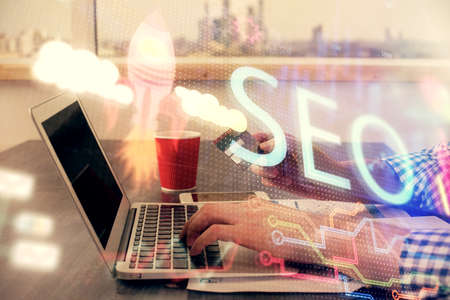 Double exposure of man hands holding a credit card and SEO drawing. Search engine optimization in...
