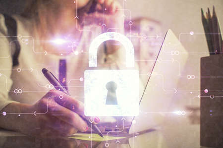 Double exposure of woman hands working on computer and lock hologram drawing. Security concept.の写真素材