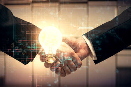 Double exposure of light bulb hologram and handshake of two men. Idea concept.