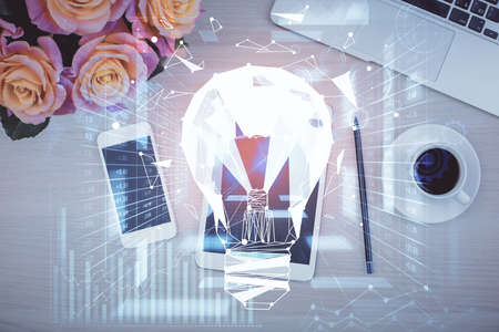 Double exposure of bulb drawing over table with phone. Top view. Concept of idea.の写真素材
