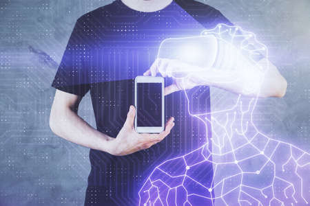 Double exposure of man's hands holding and using a digital device and AR glasses drawing. Virtual...