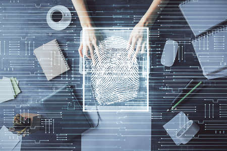 Double exposure of woman hands working on computer and fingerprint hologram drawing. Top View. Digital Security concept.の写真素材