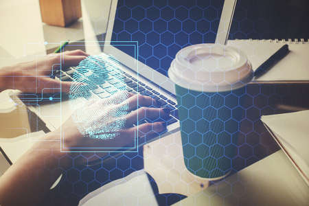 Double exposure of woman hands typing on computer and fingerprint drawing. Security concept.の写真素材