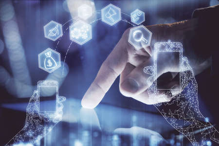 Double exposure of man's hands holding and using a digital device and tech theme hologram drawing....