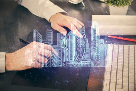 Double exposure of man's hands holding and using a digital device and city drawing.の写真素材