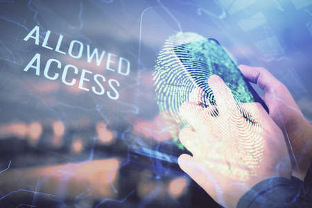 Double exposure of man's hands holding and using a digital device and fingerprint hologram drawing....