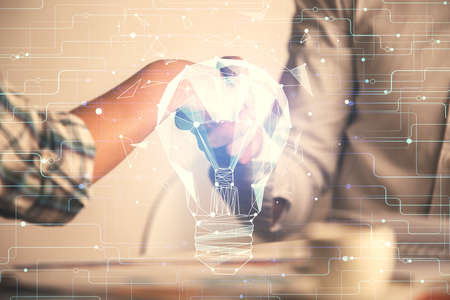 Double exposure of light bulb hologram and handshake of two men. Idea concept.