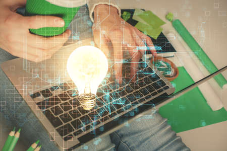 Double exposure of woman hands typing on computer and light bulb drawing. Idea concept.