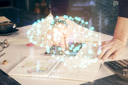 Double exposure of man's hand holding and using a digital device and brain hologram drawing. Data...