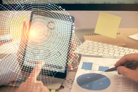 Double exposure of man's hand holding and using a digital device and brain hologram drawing. Data...