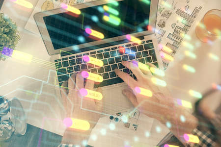 Multi exposure of man's hands typing over computer keyboard and data theme hologram drawing. Top view. Technology concept.の写真素材