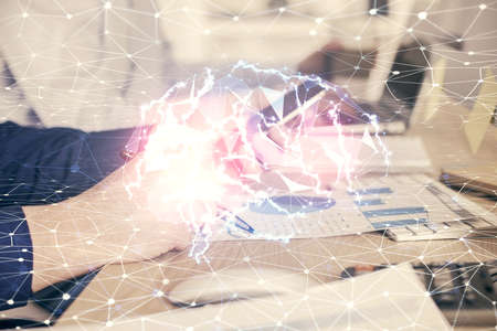 Double exposure of man's hand holding and using a digital device and brain hologram drawing. Data...
