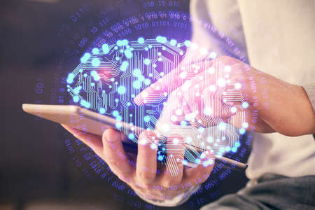 Double exposure of man's hand holding and using a digital device and brain hologram drawing. Data...