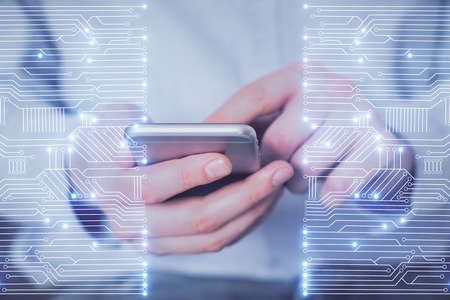 Double exposure of man's hands holding and using a digital device and tech theme hologram drawing....