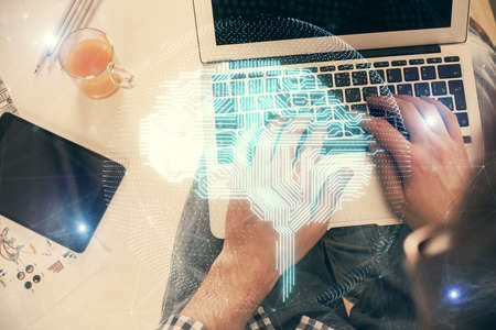 Double exposure of man's hands typing over computer keyboard and brain hologram drawing.