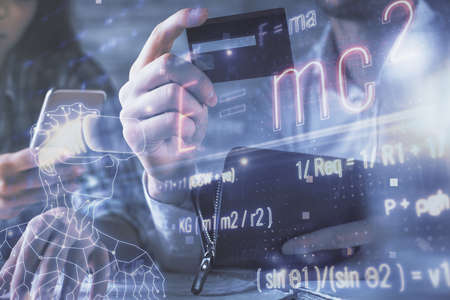 Double exposure of man and woman on-line shopping holding a credit card and formulas hologram drawing. Education E-commerce concept.の写真素材