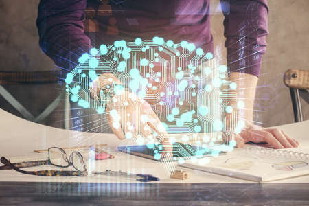 Double exposure of man's hand holding and using a digital device and brain hologram drawing. Data concept.の写真素材