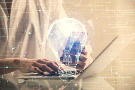 Double exposure of light bulb hologram and woman holding and using a mobile device. Idea concept.