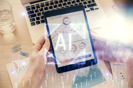 Double exposure of man's hand holding and using a digital device and data theme hologram drawing....