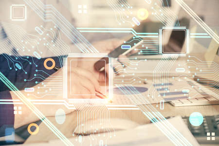 Double exposure of man's hand holding and using a digital device and data theme hologram drawing....