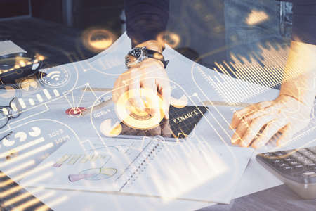 Double exposure of man's hands holding and using a digital device and tech theme hologram drawing. Technology concept.の写真素材