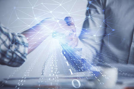 Double exposure of data theme hologram and handshake of two men. Partnership in IT industry concept.