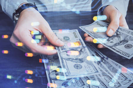 Double exposure of technology drawing hologram and us dollars bills and man hands. Data conceptの写真素材