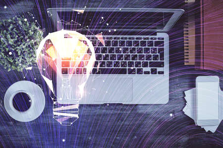 Bulb drawing over computer on the desktop background. Top view. Double exposure. Idea concept.の写真素材
