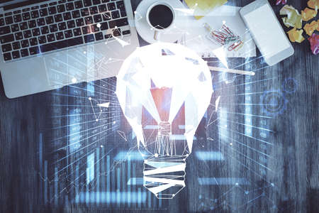 Bulb drawing over computer on the desktop background. Top view. Double exposure. Idea concept.