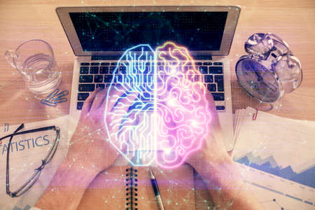 Double exposure of man's hands typing over computer keyboard and brain hologram drawing. Top view....