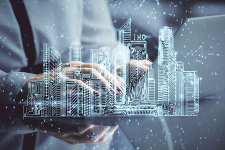 Double exposure of woman hands typing on computer and buildings drawing. Smart-city concept.の写真素材