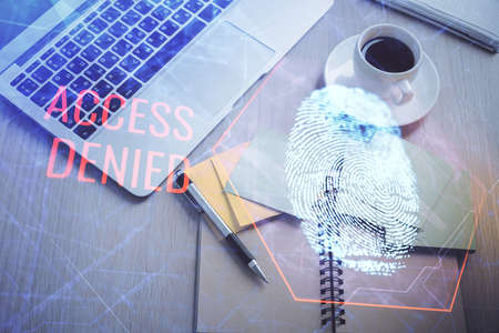 Finger print over computer on the desktop background. Top view. Double exposure. Concept of...