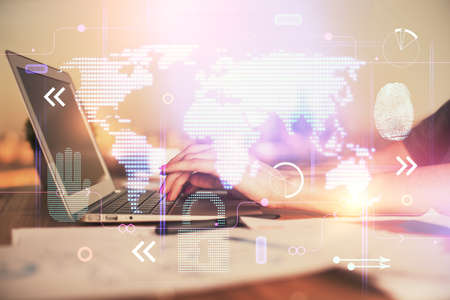 Double exposure of woman hands working on computer and world map hologram drawing. International...