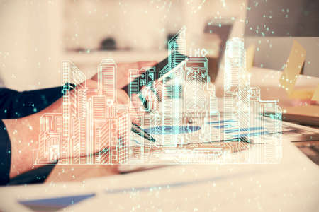 Double exposure of man's hands holding and using a digital device and city drawing.の写真素材