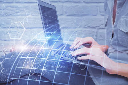 Double exposure of woman hands working on computer and world map hologram drawing. International...