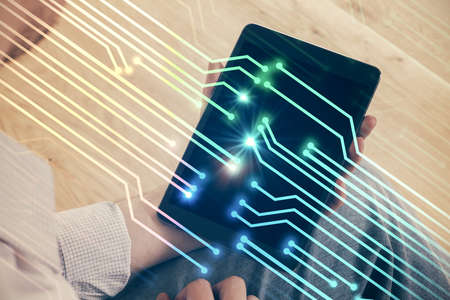 Double exposure of man's hand holding and using a digital device and data theme drawing. Technology...