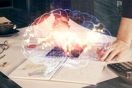 Double exposure of man's hand holding and using a digital device and brain hologram drawing. Data...