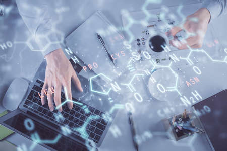Double exposure of man's hands typing over computer keyboard and formula hologram drawing. Top view. Education concept.の写真素材