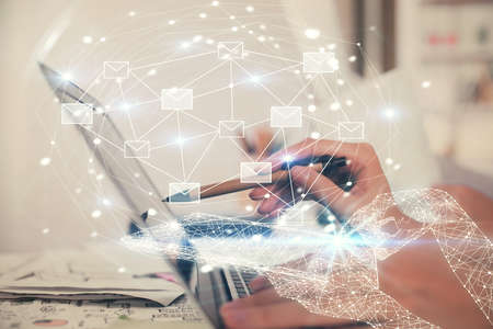 Double exposure of woman hands typing on computer and flying envelop drawing. E-Mail concept.の写真素材