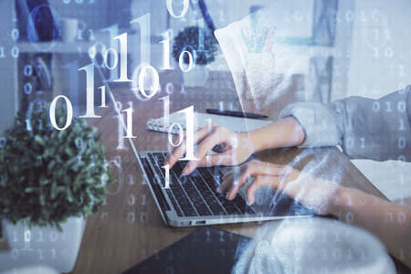 Double exposure of woman hands working on computer and data theme hologram drawing. Tech concept.の写真素材
